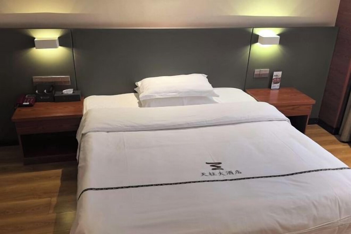 Ein Hotelzimmer mit einem Bett, Nachttischen und Wandlampen.