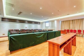 A conference room with a long table, chairs, and a wooden bench.