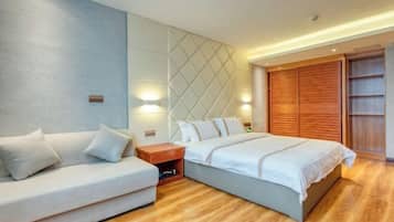 A modern bedroom with a bed, a sofa, a nightstand, and a wardrobe.