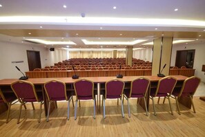 A conference room with a long table, chairs, and a stage area.