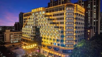 A multi-story hotel with a modern design, featuring a prominent entrance and multiple balconies.