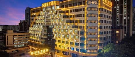 A multi-story hotel with a modern design, featuring a prominent entrance and multiple balconies.