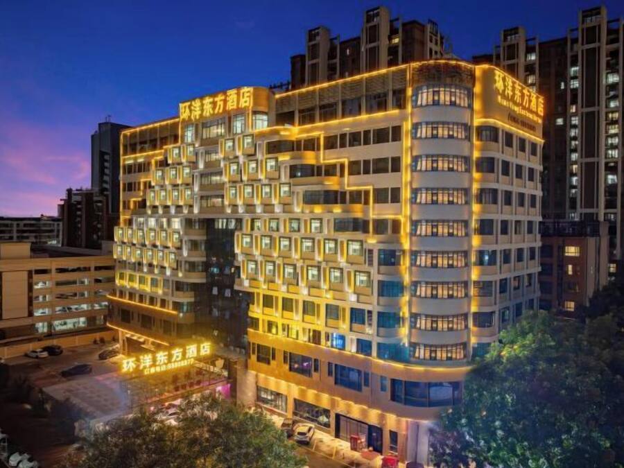 A multi-story hotel with a modern design, featuring a prominent entrance and multiple balconies.