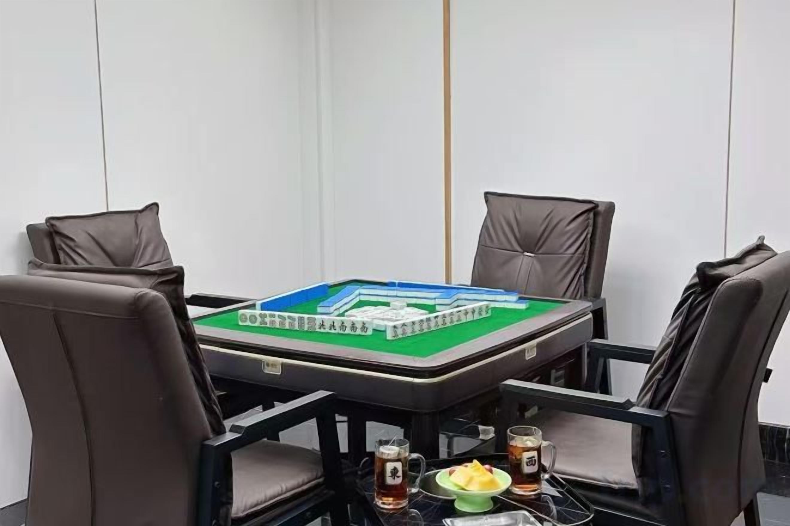 A meeting room with a table, four chairs, and a board game.