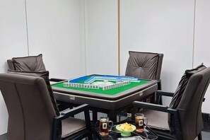 Una sala de reuniones con una mesa, cuatro sillas y un juego de mesa.