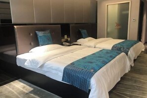 Habitación de hotel con dos camas, un cabecero grande y una puerta de cristal.