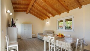 A dining area with a table, chairs, a sofa, and a window. - Holiday Home Casina Bianca with Garden, BBQ & Wi-Fi (Lurate Cacivio)