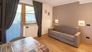 Ein Zimmer mit einer Couch, einem Tisch und Vorhängen.