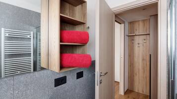 Ein Badezimmer mit einem Holzbadezimmerunterschrank, einem Handtuchwärmer und einem Spiegel.
