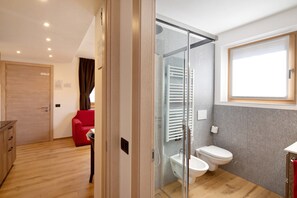 Une salle de bain moderne avec une douche à parois de verre, des toilettes et un bidet.