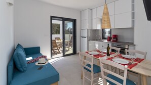 Een moderne, compacte woonruimte met een eethoek, kitchenette en een bank met uitzicht.