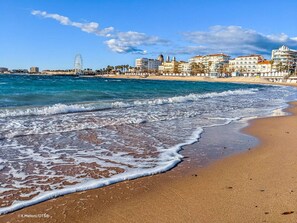 A beach with waves, a Ferris wheel, and buildings in the background. - Comfortable 3-Room Apartment with Terrace and Pool in Saint-Raphaël (Saint-Raphaël)
