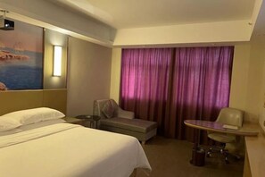 A hotel room with a bed, a desk, a chair, and a large window with curtains. - Vienna Hotels（hunan zhuzhou green shop） (Zhuzhou)