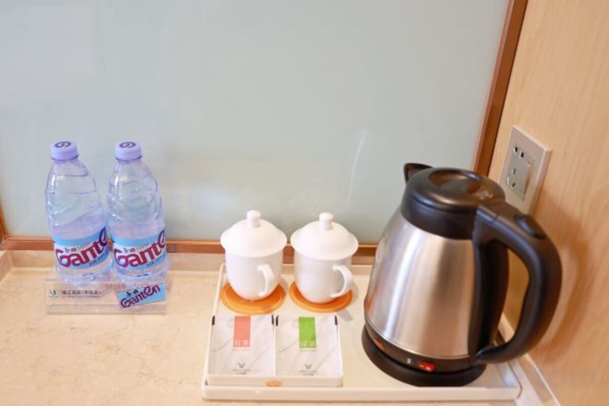 A kitchen counter with two water bottles, a coffee maker, and a scale.