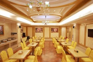 A banquet hall with rows of tables and chairs, a chandelier, and artwork on the walls. - Vienna Hotels（hunan zhuzhou green shop） (Zhuzhou)