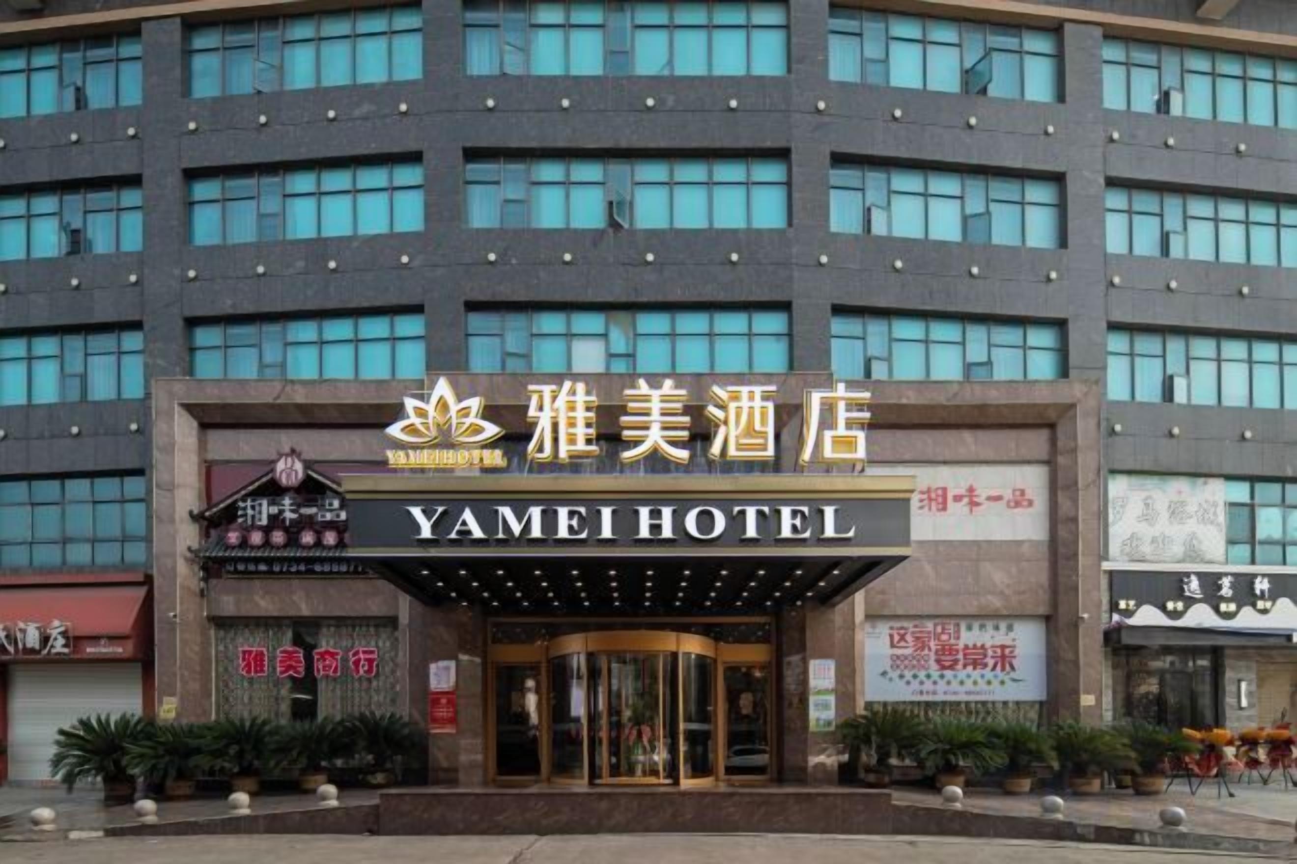 A hotel with a prominent entrance, multiple floors, and a sign indicating it is the Yamei Hotel.