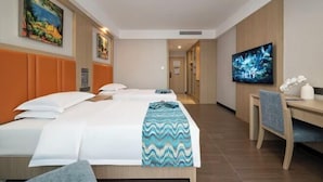 Ein Hotelzimmer mit zwei Betten, einem Schreibtisch und einem Fernseher.