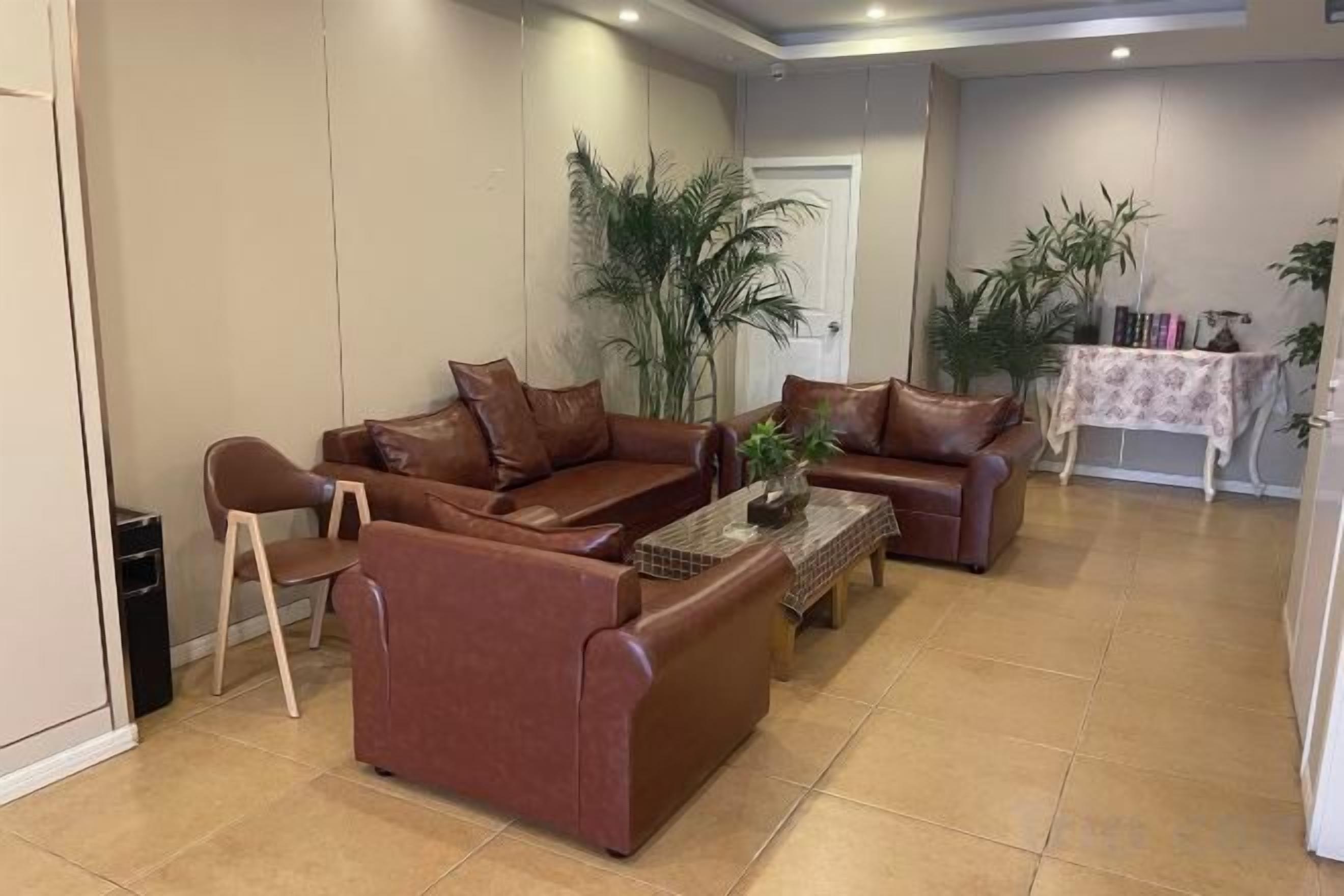 Un salon comprenant un ensemble de canapés marron, une table basse et un coin repas avec une table et des chaises.