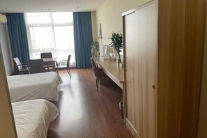 A hotel room with two beds, a desk, a chair, and a large window with curtains. - Pebble Motel (Jianhu Bus Station) (Jianhu)