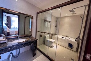 Une salle de bain moderne avec une douche à parois de verre, un lavabo en marbre et un grand miroir.
