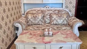 A vintage sofa with floral upholstery and a marble-patterned table in front. - hide bdr hotel (Diebu)