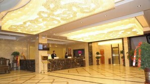 A hotel lobby with a marble reception desk, a large chandelier, and a reception area. - hide bdr hotel (Diebu)