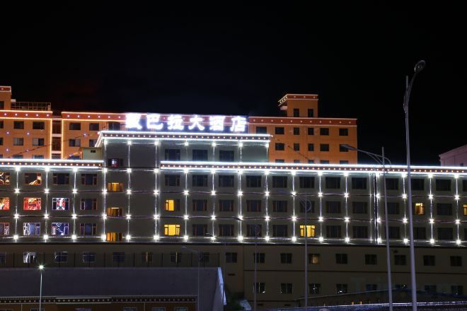 Un immeuble d’hôtel à plusieurs étages, doté d’une enseigne lumineuse et de nombreuses fenêtres.