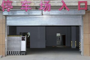 A garage entrance with a metal door and a sign above it.