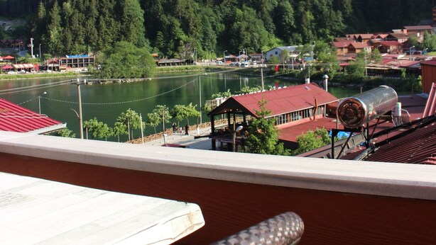 A view from a balcony overlooking a lake, surrounded by forested hills. - Uzungol Adiloglu Apart (Çaykara)