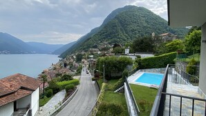Eine Stadt an einem Hügel mit freiem Blick auf den See, einem Schwimmbecken und einer Straße, die zum Wasser hinabführt.