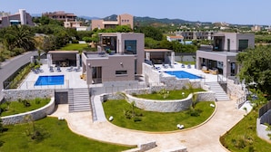 Una moderna località turistica con piscina, posti a sedere all'aperto e un vialetto in pietra.
