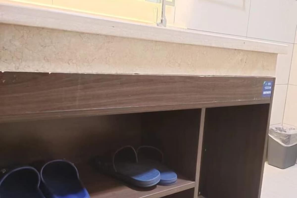 Een houten plank met een paar blauwe en een paar zwarte pantoffels.