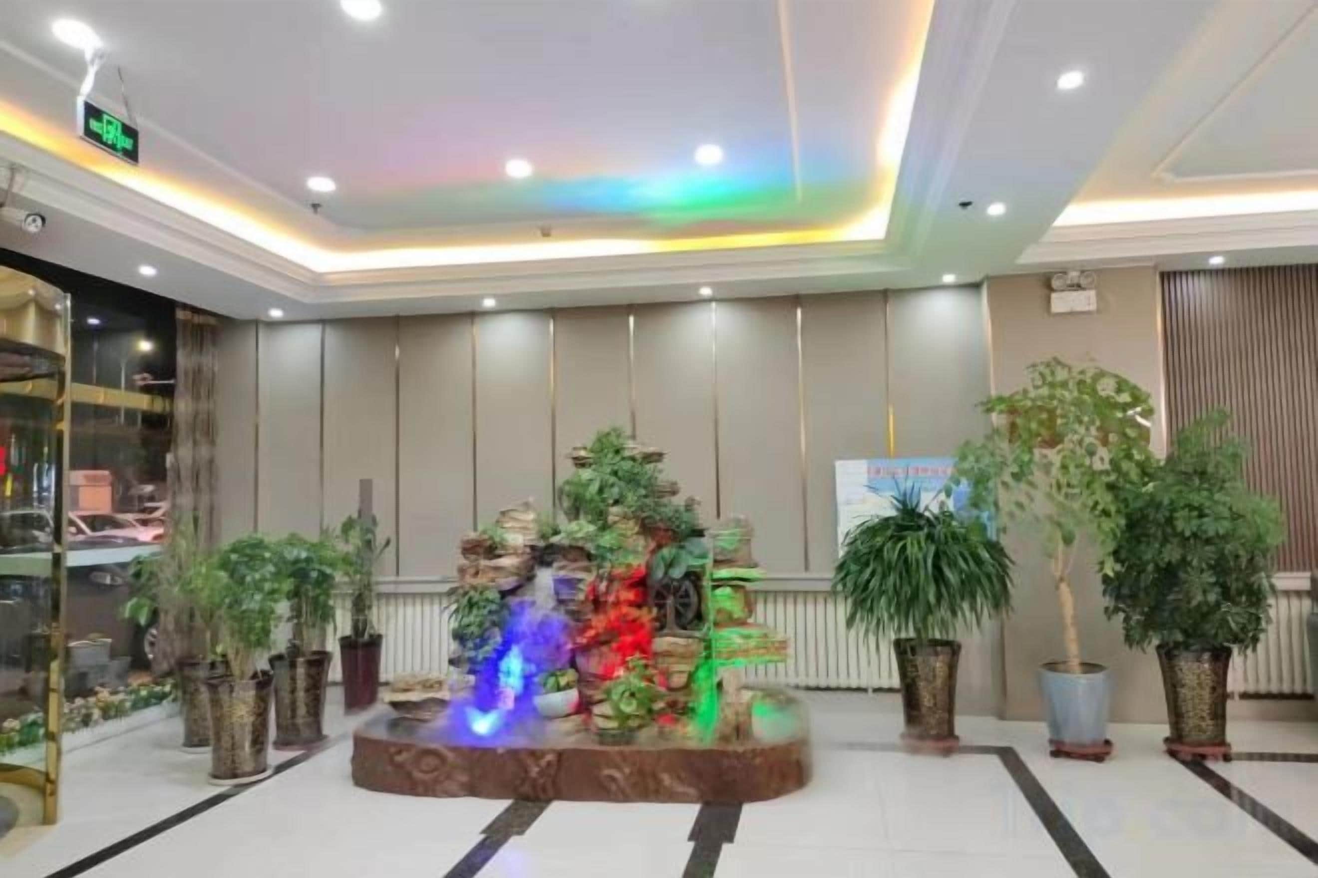 A lobby with a water feature, potted plants, and a reception desk.