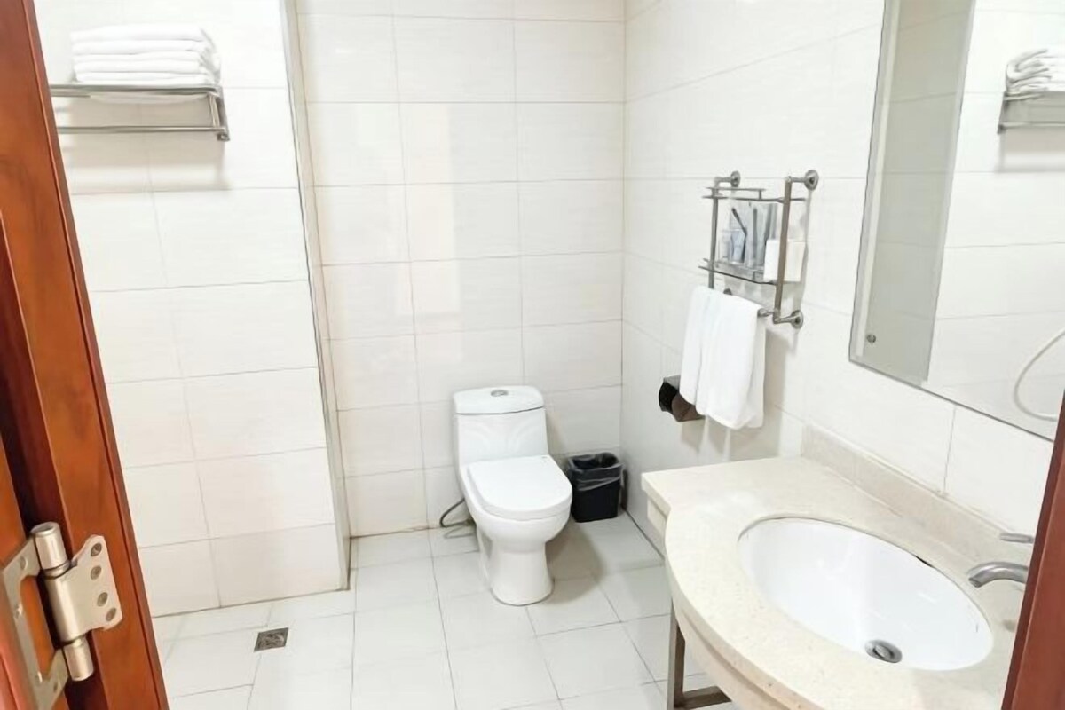Un baño con inodoro, lavamanos y espejo.