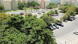 A residential area with multiple apartment buildings, a parking lot, and a road with vehicles. - KSLV - Furnished Studio (Dubai)