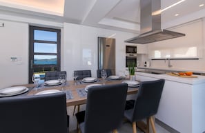 A modern kitchen with a dining area.