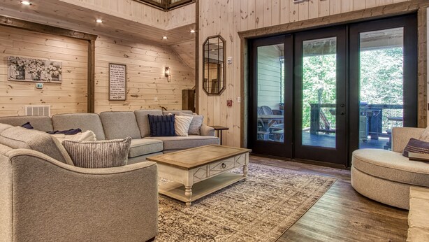 Un intérieur chaleureux avec un canapé, une table basse et une enseigne indiquant « Soaky Mountain Lodge ».