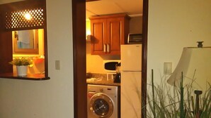 Een wasserette met een wasmachine, een droger en houten kastjes.