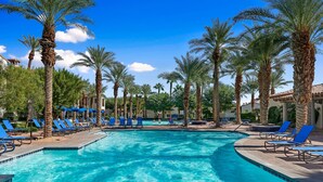 A pool area with blue lounge chairs and palm trees. - Luxurious 2 Story Townhome - Newly Remodeled! 3 Bedroom Condo by RedAwning (La Quinta)