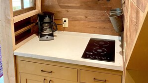 A compact kitchen with wooden cabinetry, a built-in stove, and a coffee maker. - the suite @ barn & bike - private, bucolic, serene setting (Red Hook)