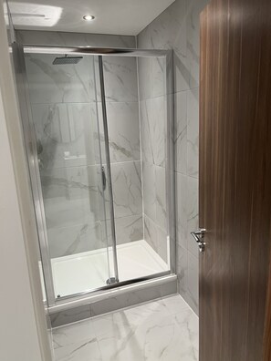 Superior appartement | Badkamer | Een douche, handdoeken