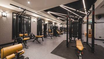 A modern gym with various exercise equipment, including weight machines and benches.