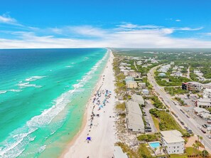 A coastal town with a beach, buildings, and a road.