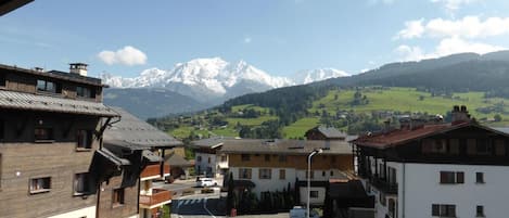 A mountain town with buildings and a road leading to a parking area.