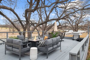 Une terrasse aménagée avec des meubles d’extérieur, un foyer et un barbecue.