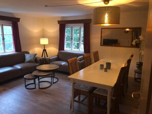 Un salon confortable avec un canapé, une table à manger et une lampe.