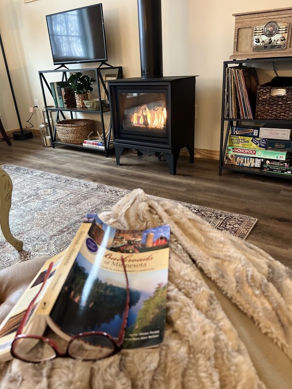 Una sala de estar acogedora con chimenea, televisor y estantería.
