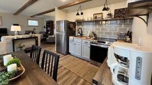 A modern kitchen with a built-in oven, a coffee maker, and a refrigerator.