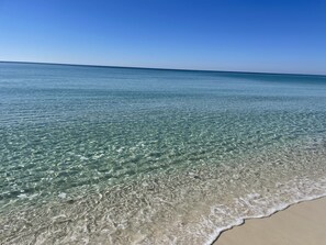En strand med klart, grunt vatten och en sandstrand.