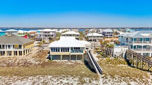 A coastal residential area with beachfront properties, including houses with balconies and a pier. - Poseidon's Rest | Gulf Front Home | Gorgeous Gulf Views | Dune Walkover (Navarre Beach)